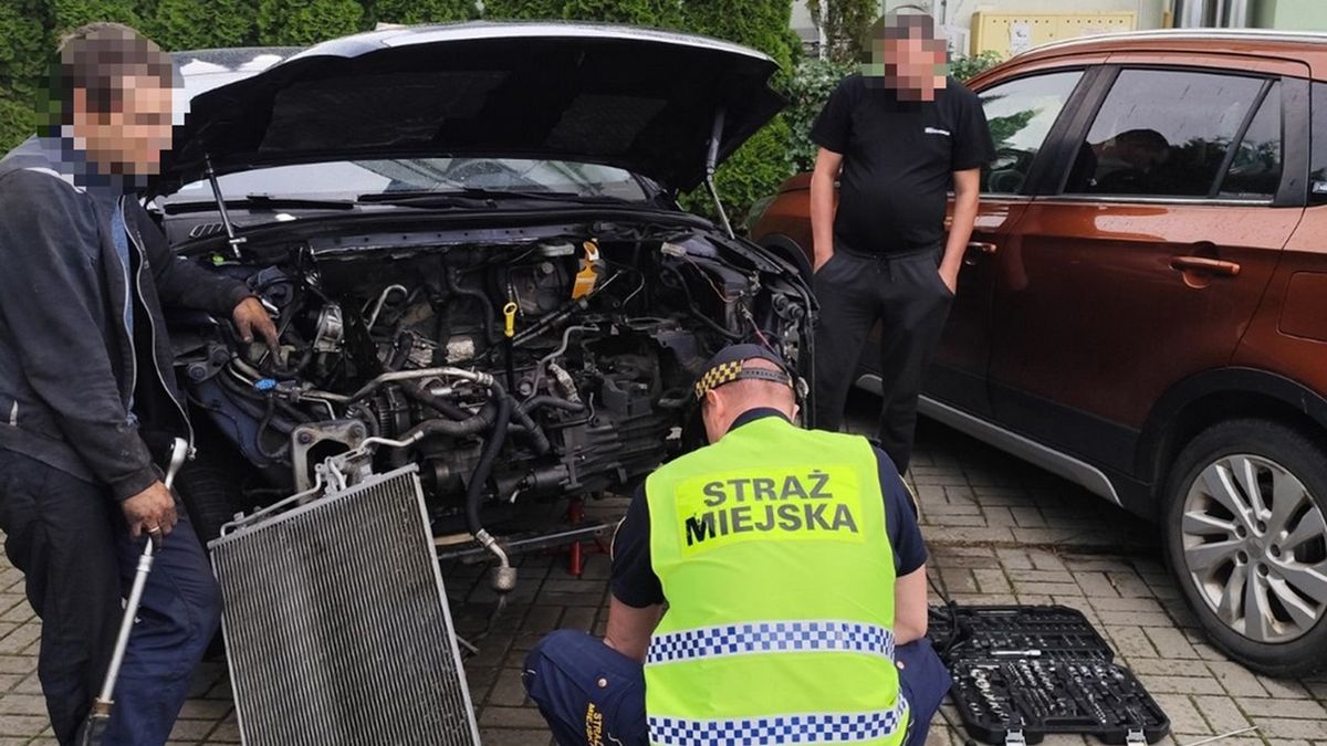 Mężczyźni naprawiali samochód, z którego wyciekały płyny