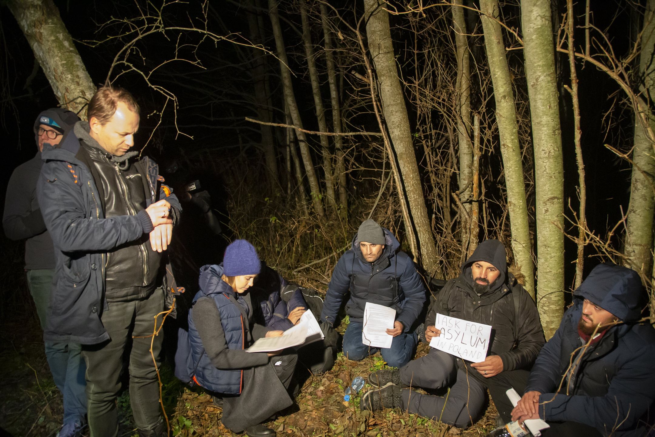 06.11.2021  Teremiski  . interwencja z aktywistami Grupy Granica . 4 Syryjczykow , wielokrotnie wywozonych na pas graniczniczy z Bialorusia w ramach pushback  przez Straz Graniczna . 23 pazdziernika w kolo Hajnowki , w Lipinach Medycy na Granicy udzielili jednemu z nich pomocy medycznej , poniewaz byl w ciezkiej hipotermi , i po pobycie w szpitalu , zostali znow wywiezieni . Prosza o azyl w Polsce , ich prawnym pelnomocnikiem sa Maciej Stuhr (1L) , aktor i jego zona Katarzyna Blazejewska - Stuhr (2L). Przedstawili oni pogranicznikom  rowniez list z MTPC zakazujacy kolejnej wywozki na granice .
Fot. Agnieszka Sadowska/ Agencja Wyborcza.pl *** Local Caption *** .Fot. Agnieszka Sadowska / Agencja Wyborcza.pluchodzcy, refugees, straz graniczna, pushback, azyl, ochrona miedzynarodowa, /FR/