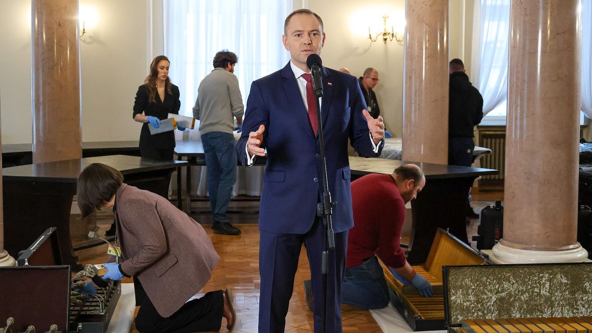 Karol Nawrocki przemawia na tle osób, rozmontowujących Okrągły