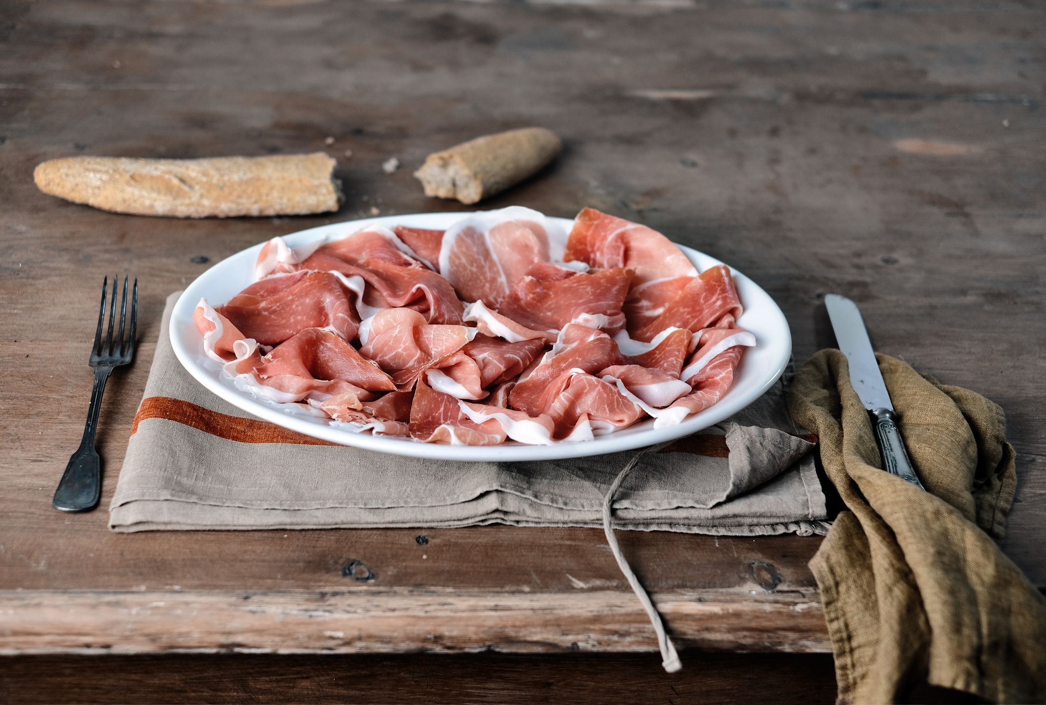 Prosciutto crudo powstaje z solonego udźca wieprzowego.