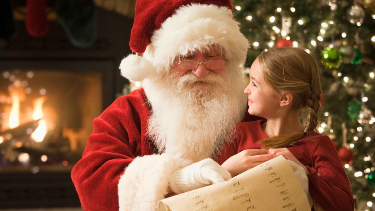 Dziewczynka siedzi  na kolanach św. Mikołaja