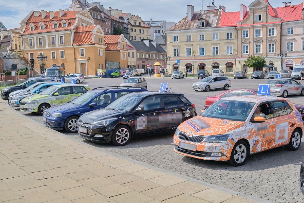 Samochody nauki jazdy blokują miejsca parkingowe na pl. Zamkowym w oczekiwaniu na kursantów
