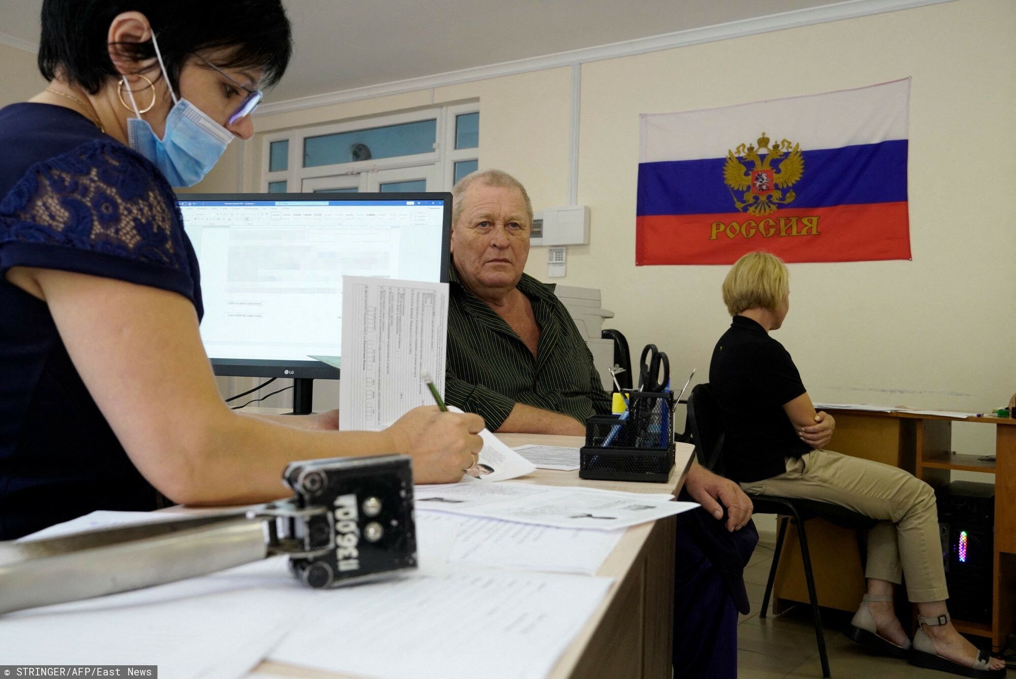 TemporaryA man fills document to apply for new Russian passport at a centre in Melitopol in Zaporizhzhia region, on August 3, 2022, amid the ongoing Russian military action in Ukraine. (Photo by STRINGER / AFP)STRINGER
