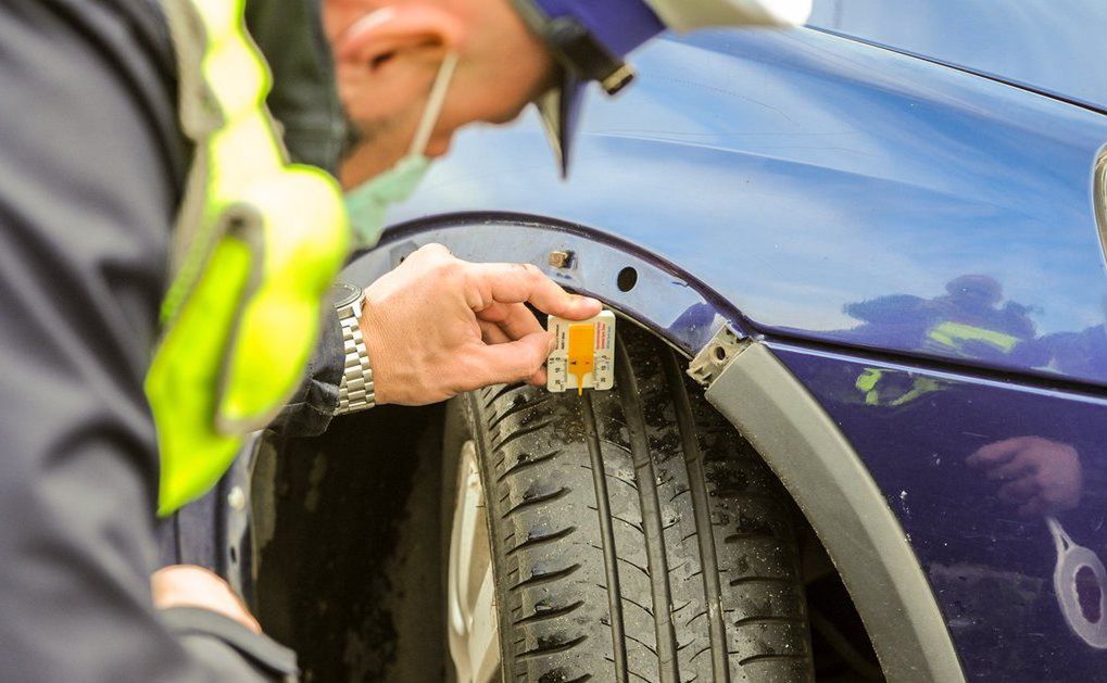 Policjant mierzy grubość bieżnika