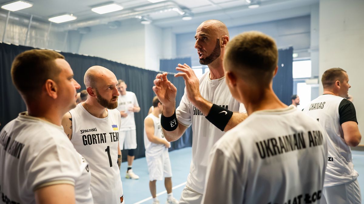 Marcin Gortat rozmawia z ukraińskimi żołnierzami, którzy wystąpili w jego zespole w charytatywnym meczu z Wojskiem Polskim