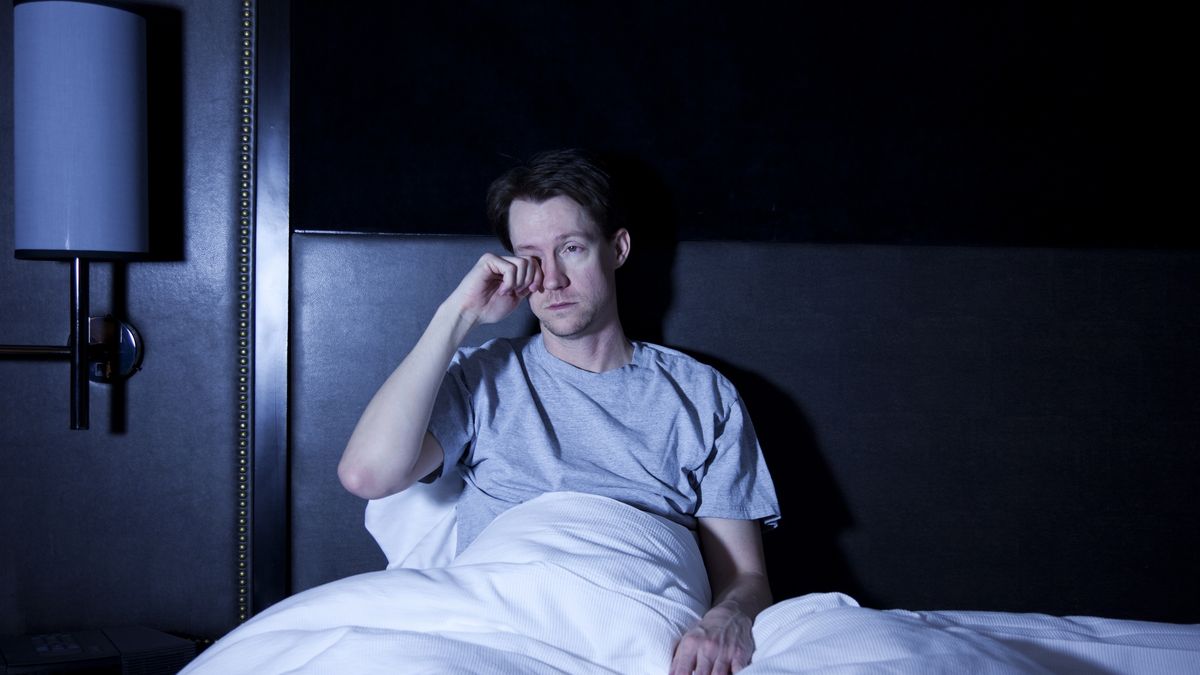 InsomniacPhoto of a man sitting in a hotel room bed bed, rubbing his tired eyes as he watches late night television with the remote control in his lap.jhorrocks30s, 40-45 Years, Adult, Adults, Baggy Eyes, Bed, Bedroom, Bedtime, Blue, Boredom, Brown Hair, Candid, Caucasian, Concepts And Ideas, Copy Space, Dark, Dark Circles, Depression, Distracted, Distraught, Duvet, Emotional Stress, Exhaustion, Frowning, Frustration, Gel Effect, Home Interior, Hotel Room, Human Eye, Indoors, Insomnia, Lifestyle, Loneliness, Male, Night, One Man Only, One Person, People, People, Problems, Real People, Remote Control, Rubbing, Rubbing Eyes, Sadness, Sitting, Sleeping, Solitude, T-Shirt, Time, Time, Tired, Travel, Waiting, Waking up, Watching TV, White, Worried