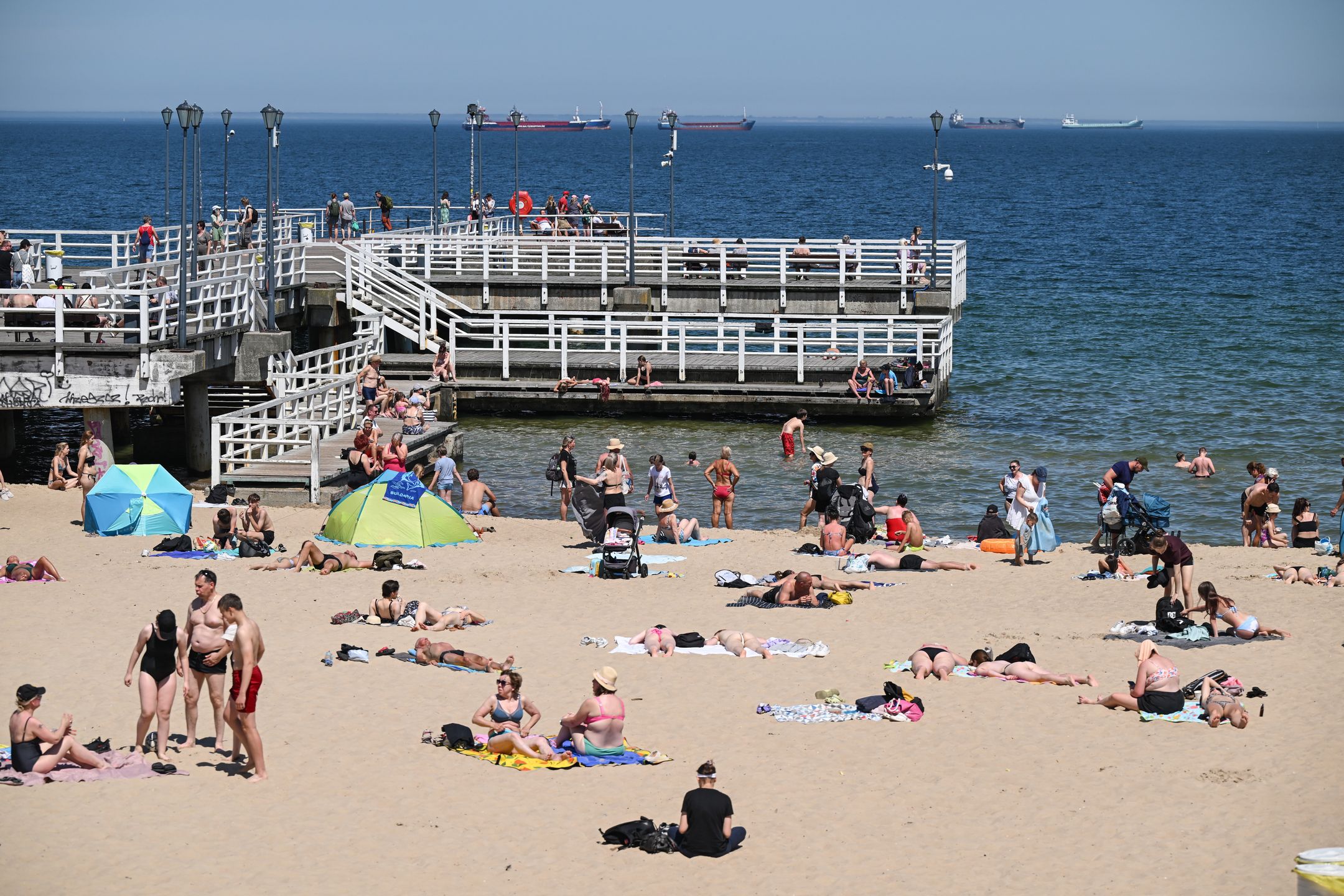 Gdańsk, 02.07.2025. Plażowicze wypoczywają korzystając ze słonecznej pogody na plaży w Gdańsku-Brzeźnie, 2 bm. Nad Polskę nadciągnęła fala upałów. IMGW wydał ostrzeżenia I i II stopnia przed upałem dla całego kraju. Ostrzeżeniem II stopnia objęto pas północno-wschodniej, centralnej i południowo-zachodniej Polski. (amb) PAP/Adam Warżawa