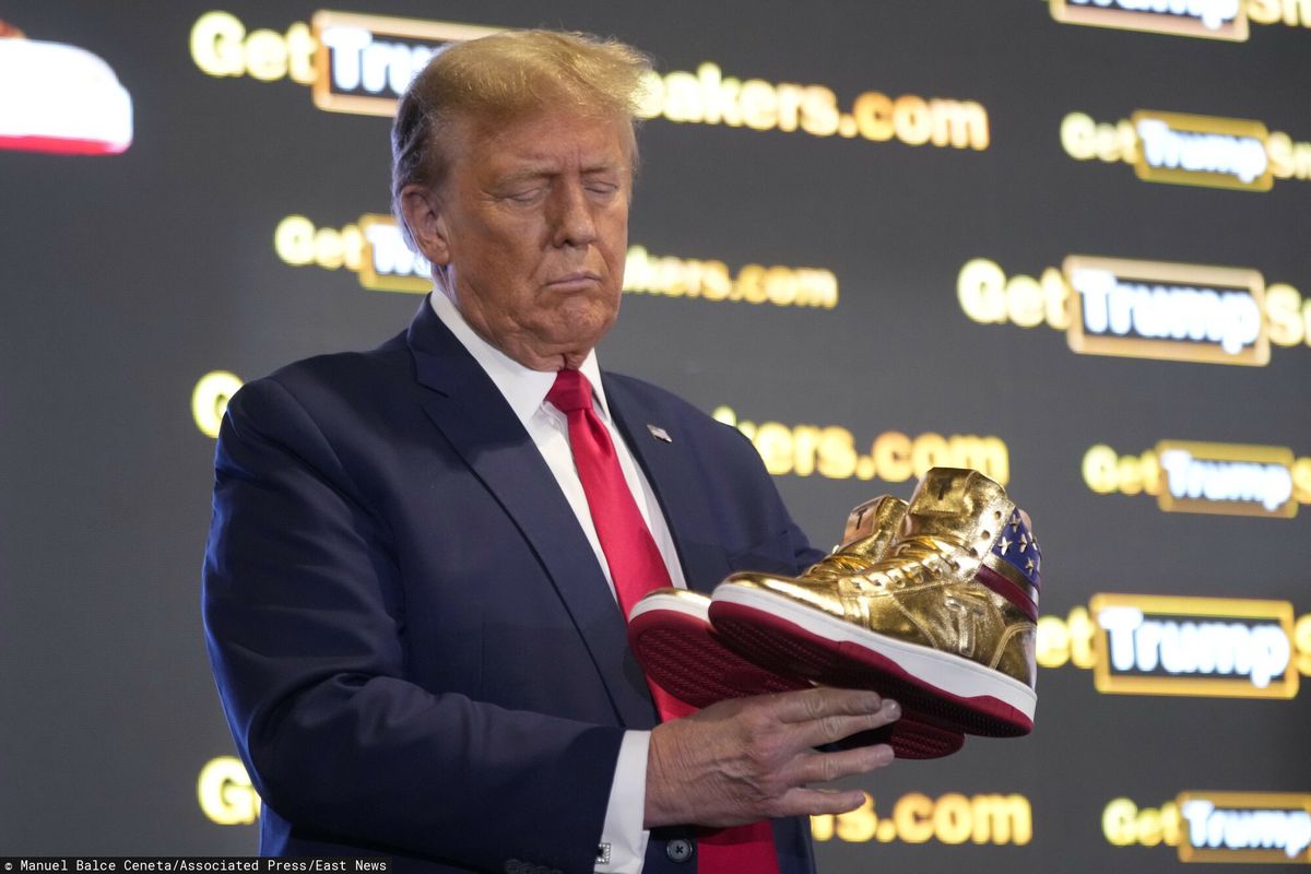 Donald Trump prezentuje swoje złote buty.
