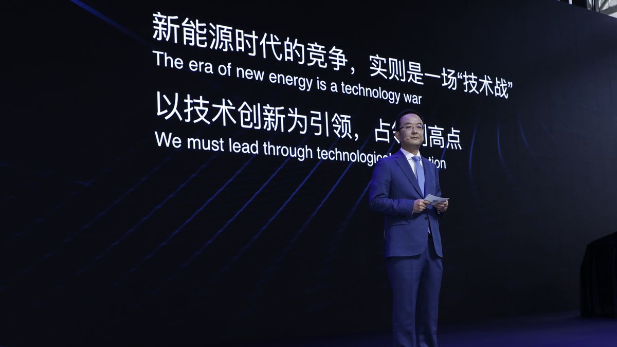 An Conghui (dyrektor Geely Auto Group) przed slajdem o treści "era nowej energii to wojna technologiczna".