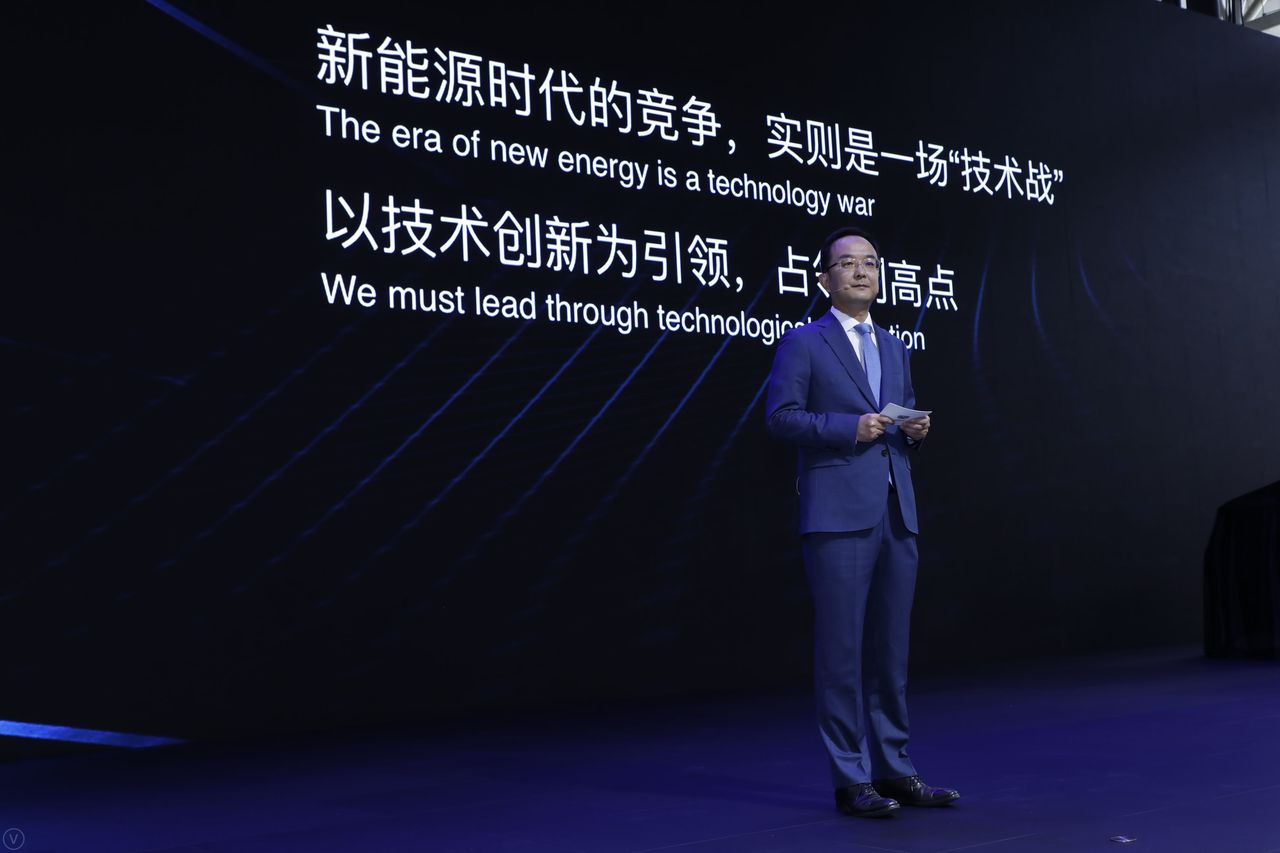 An Conghui (dyrektor Geely Auto Group) przed slajdem o treści "era nowej energii to wojna technologiczna".