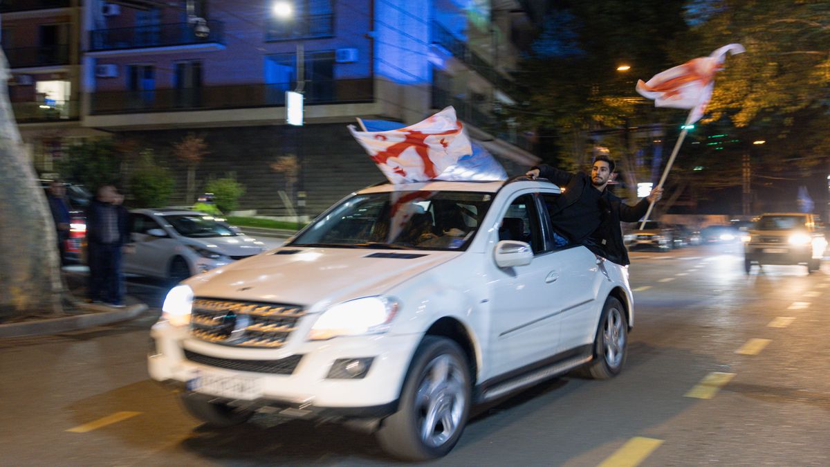 TBILISI, GEORGIA - OCTOBER 26: Georgian Dream Party supporters celebrate the exit poll results outside the new Georgian Dream headquarters during Georgian Election Day on October 26, 2024 in Tbilisi, Georgia. Georgians are voting on October 26, in a close parliamentary election that analysts say will likely determine whether or not the post-Soviet nation will take a step closer to membership in the European Union (EU). An opposition coalition is challenging the Georgian Dream ruling party, which has been in power since 2012 under the leadership of Bidzina Ivanishvili. The vast majority of Georgians are in favor of joining the EU, however the country's bid to become a member of the bloc was frozen earlier this year, following concerns over the "foreign agents" bill passed in May, which critics say represents a backslide for democracy. (Photo by Diego Fedele/Getty Images)