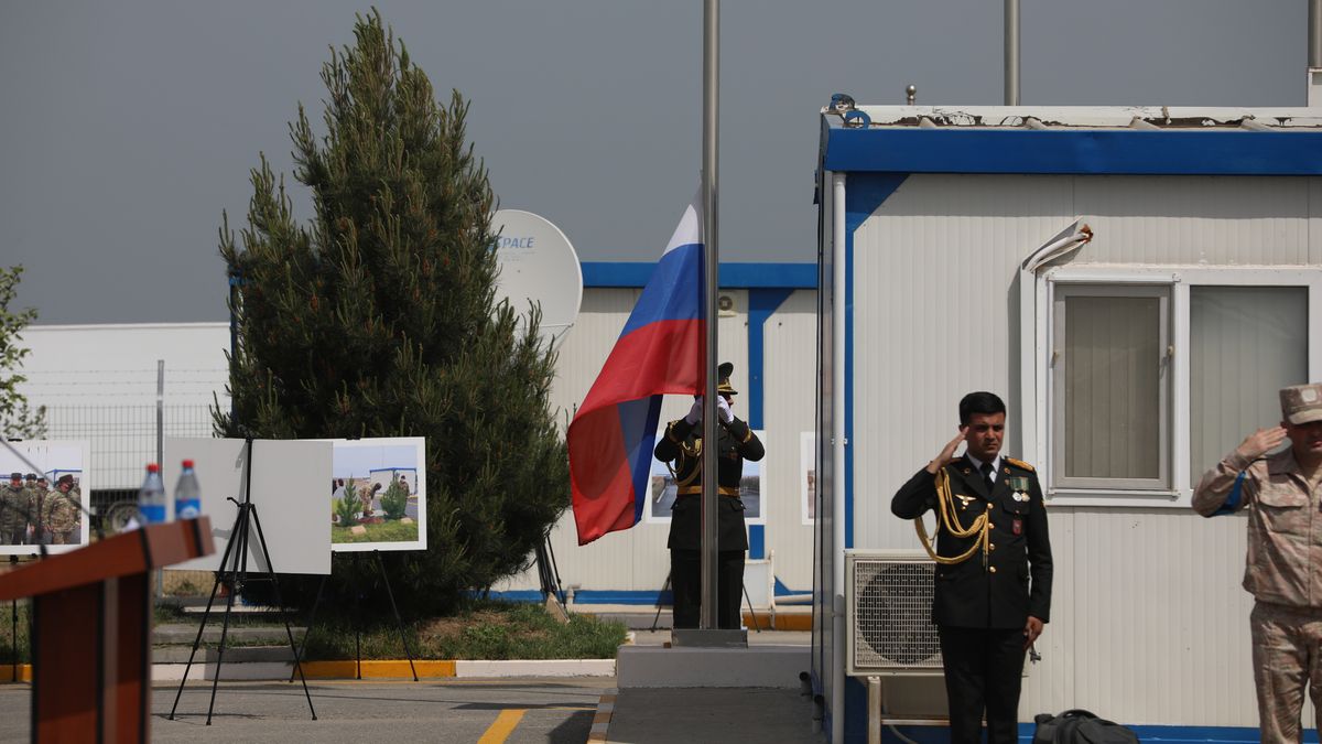 Żołnierze salutujący do rosyjskiej flagi