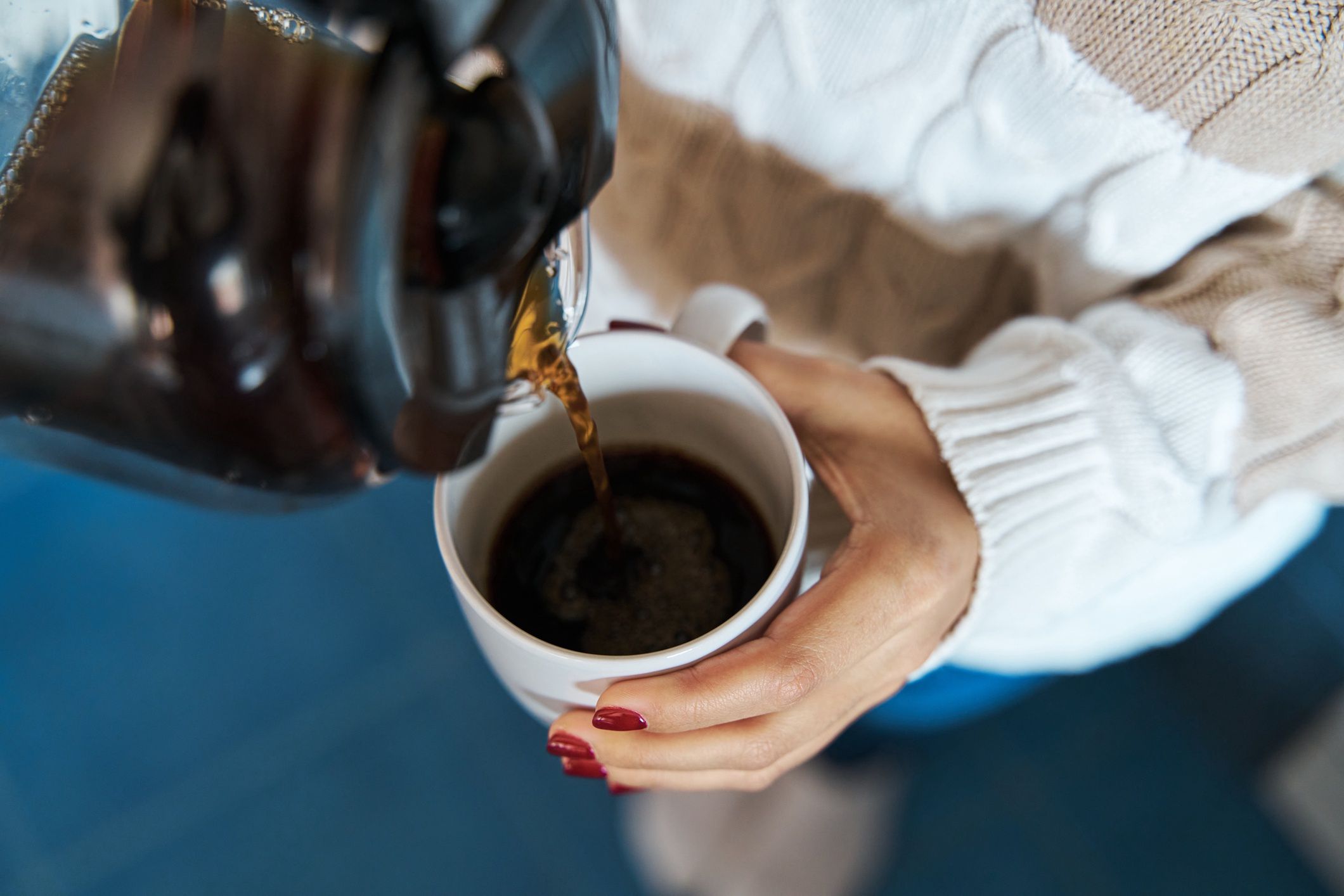 Woman pouring hot coffee to a mug at home.
Woman pouring herself hot coffee to a mug at home.
juanma hache