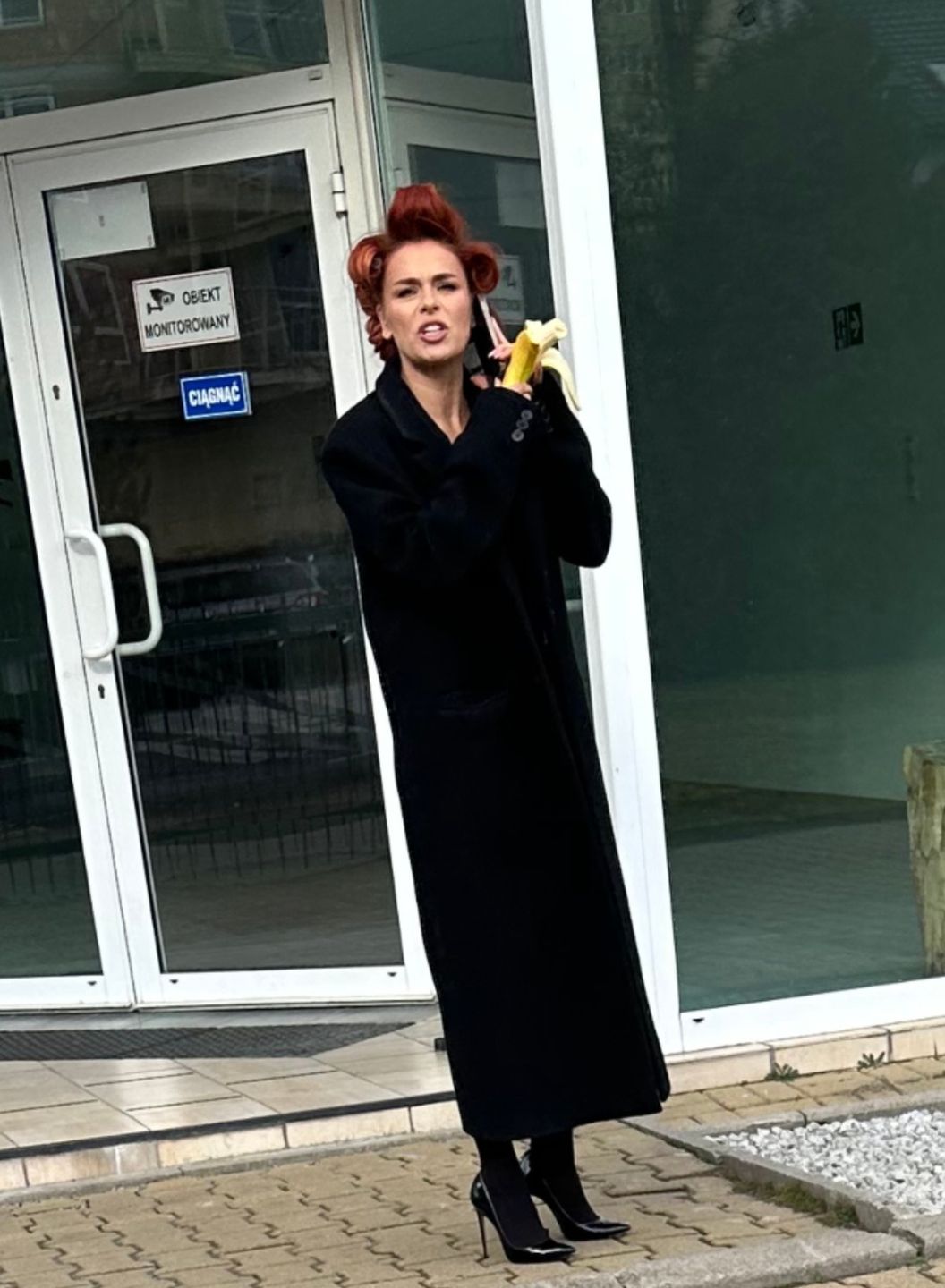 Natasza Urbańska wcina banana z wałkami na głowie