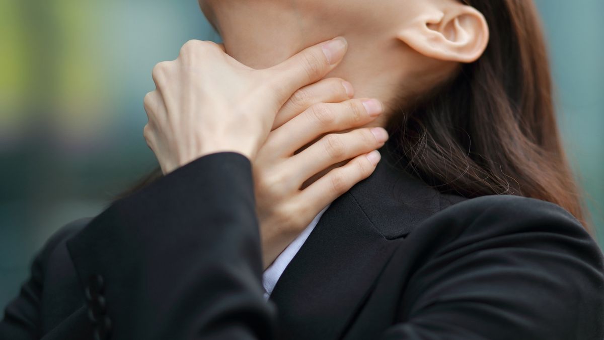 Businesswoman with neck pain outdoorsRUNSTUDIO