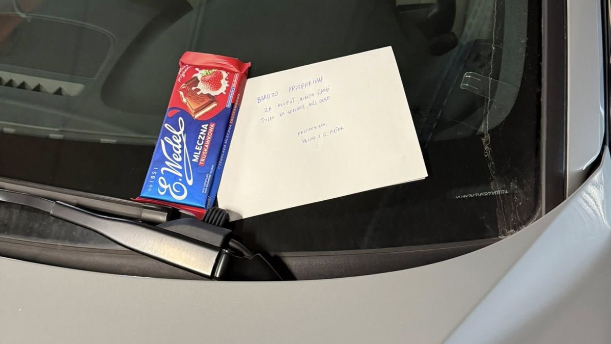 Liścik i czekolada za wycieraczką auta.