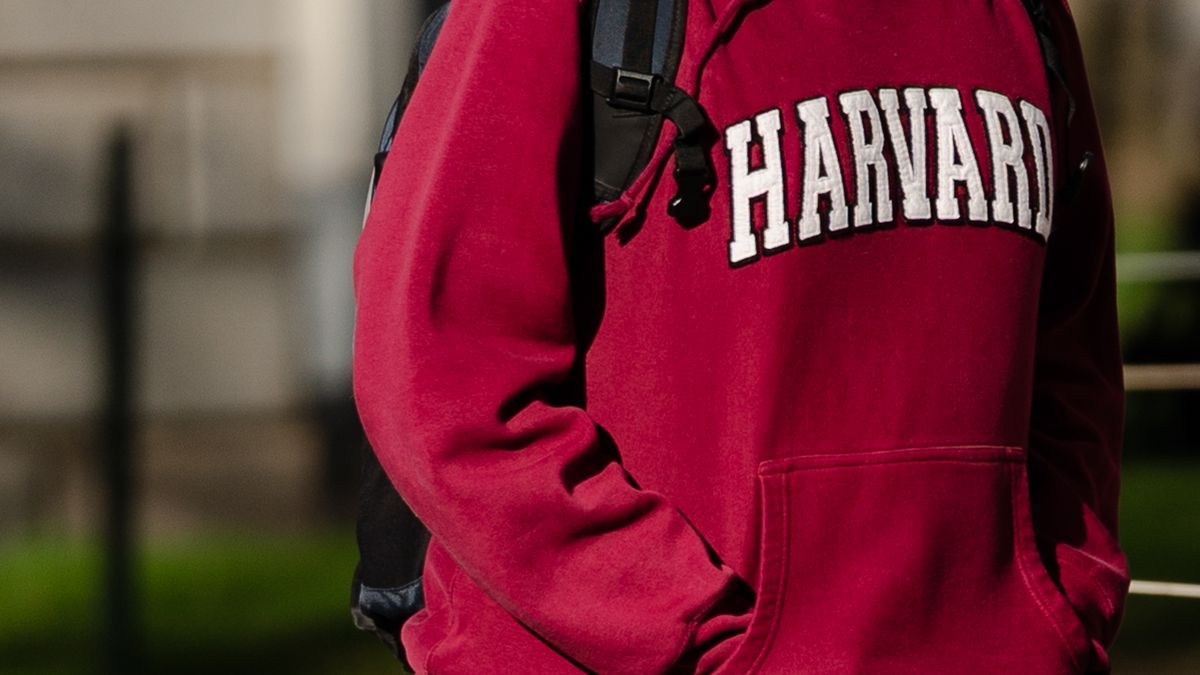A pedestrian wearing a Harvard University sweatshirt on the Harvard University campus in Cambridge, Massachusetts, US, on Wednesday, April 16, 2025. President Donald Trump escalated his administration's fight with Harvard University by threatening its tax-exempt status after the school defied the government's demands to change its policies in exchange for billions of dollars of federal funding. Photographer: Sophie Park/Bloomberg via Getty Images