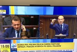 Symboliczne zdjęcie. Z mównicy lecą zarzuty, a w tym czasie Błaszczak cieszy się do telefonu
