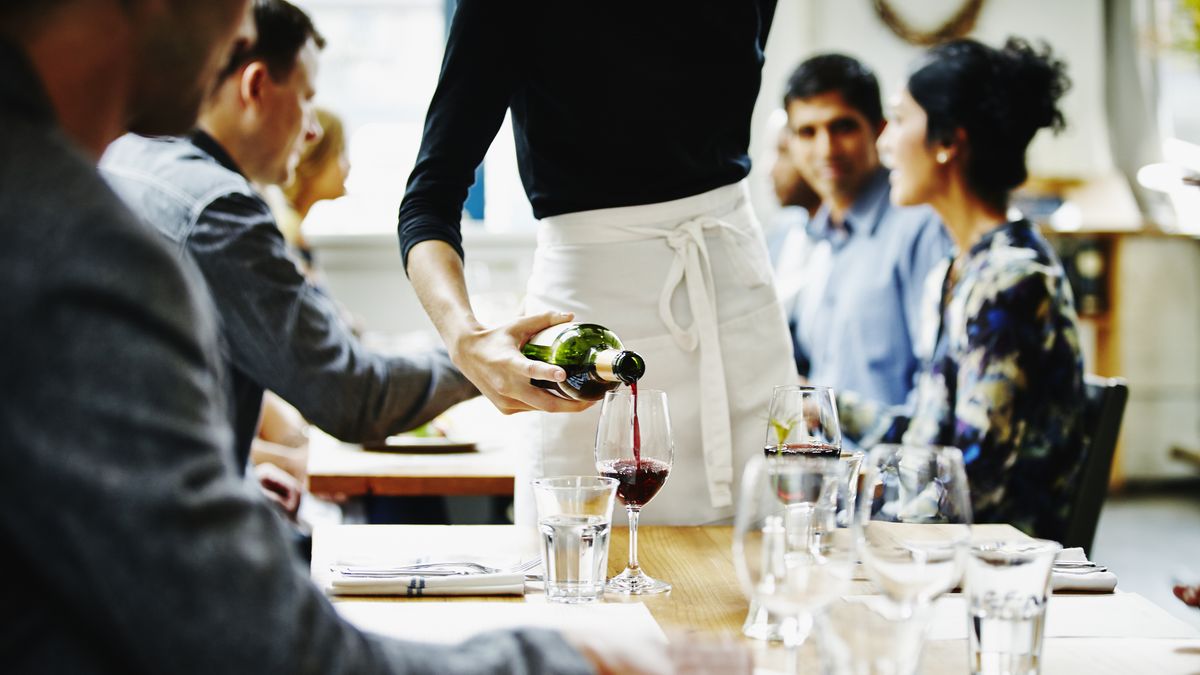 Waitress pouring wine into glass at tableWaitress pouring wine into glass at table in restaurantThomas BarwickAnticipation, Celebration, Refreshment, Sensory Perception, Service