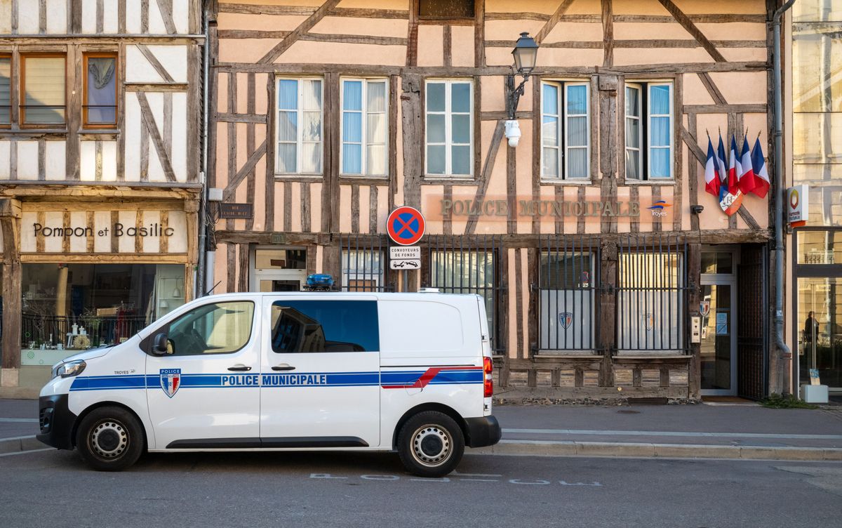 French tricolor flags fly outside the medieval building housing the municipal police station with a police van in Troyes, Aube, France. (Photo by: Andy Soloman/UCG/Universal Images Group via Getty Images)