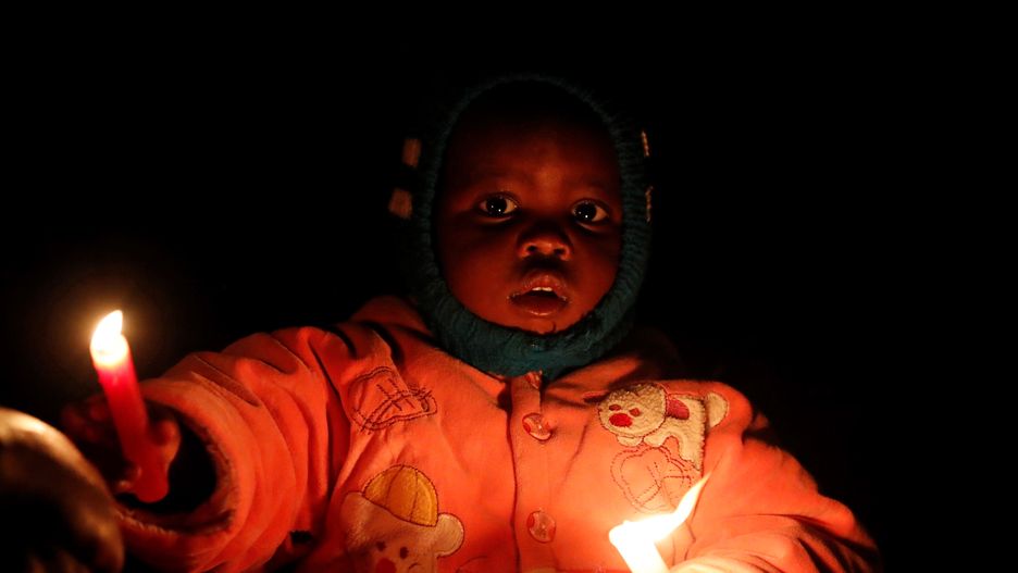 A child of the Legio Maria African Mission church holds candles while attending the Christmas eve vigil mass in their church in the Fort Jesus area of Nairobi, Kenya December 25, 2019.