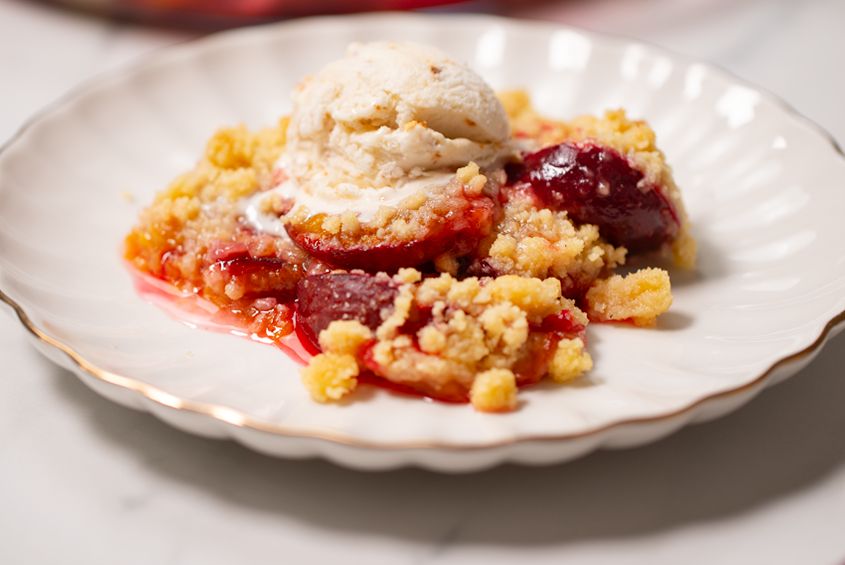 Ułóż śliwki w formie i posyp je kruszonką. O tym deserze na ciepło będziesz śnił po nocach