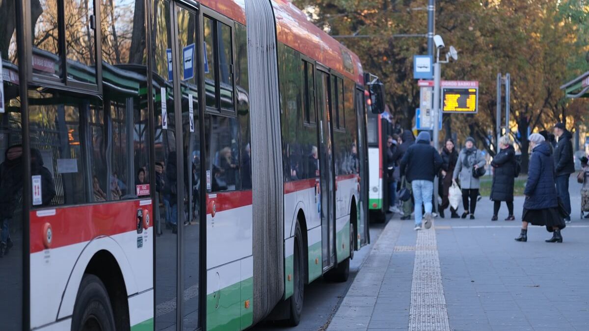 Pasażerowie wsiadający do autobusu na przystanku