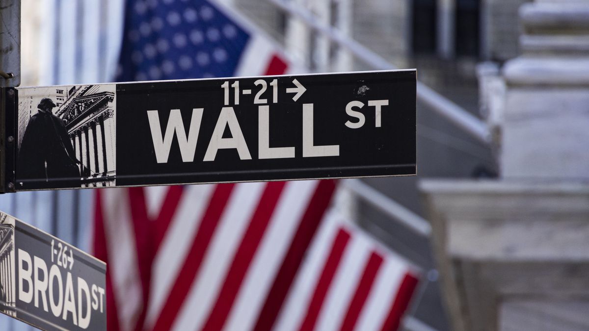 Wall Street sign inscription as seen with the American flag in the background on the road and buildings of Wall St, downtown in lower Manhattan as the area is a significant financial district for the American and the global economy, banking system and markets with the headquarters of companies and financial institutions located there like the New York Stock Exchange NYSE. New York City, USA on November 12, 2024 (Photo by Nicolas Economou/NurPhoto via Getty Images)