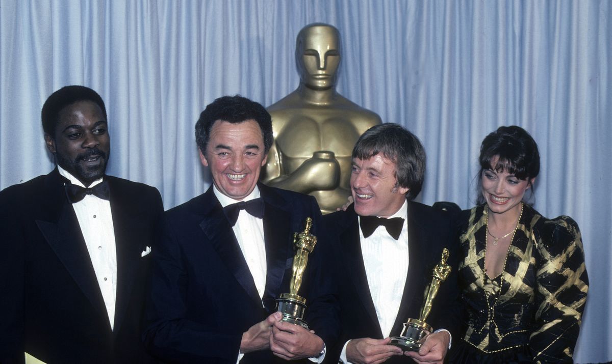 HOWARD E. ROLLINS, JR.;NORMAN REYNOLDS;MICHAEL FORD;KAREN ALLENTHE 54TH ANNUAL ACADEMY AWARDS - Backstage Coverage - Airdate: March 29, 1982. (Photo by ABC Photo Archives/Disney General Entertainment Content via Getty Images)NORMAN REYNOLDS (C, L) AND MICHAEL FORD (C, R), BEST ART DIRECTION WINNERS FOR "RAIDERS OF THE LOST ARK" WITH PRESENTERS HOWARD E. ROLLINS, JR. AND KAREN ALLENABC Photo ArchivesOSCARS