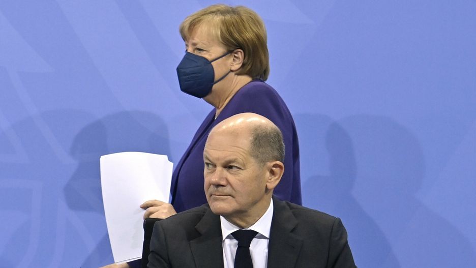 TemporaryGerman Chancellor Angela Merkel, background, and Finance Minister Olaf Scholz arrive for a press conference following a meeting with the heads of government of Germany's federal states at the Chancellery in Berlin, Thursday, Dec. 2, 2021. Merkel said Thursday that people who aren't vaccinated will be excluded from nonessential stores, cultural and recreational venues, and parliament will consider a general vaccine mandate, as part of an effort to curb coronavirus infections that again topped 70,000 newly confirmed cases in a 24-hour period. (John Macdougall/Pool Photo via AP)AFP
