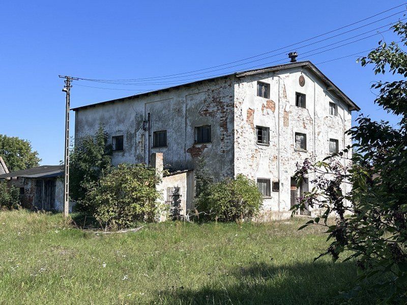 Po drugiej stronie ulicy stoją opuszczone budynki gospodarstwa rolnego