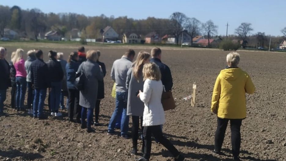 Pracownicy Awtotoru oglądają teren, przeznaczony pod warzywne działki. Będą je uprawiać na przymusowym urlopie 