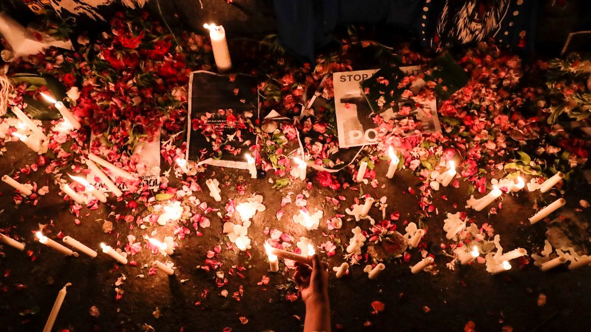 ludzie zapalają świece upamiętniające ofiary w Malang