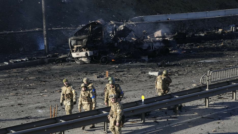 Inwazja na Ukrainę walki toczą się juz w Kijowie. Na fot. ukraińscy żołnierze przy szczątkach wojskowej ciężarówki