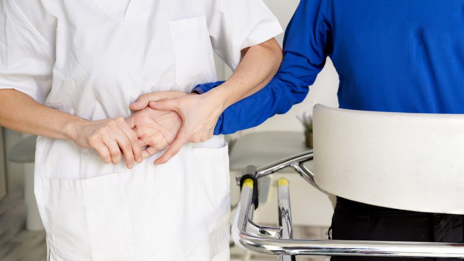 Physiotherapist assisting a patient with Amyotrophic Lateral Sclerosis. High quality photo