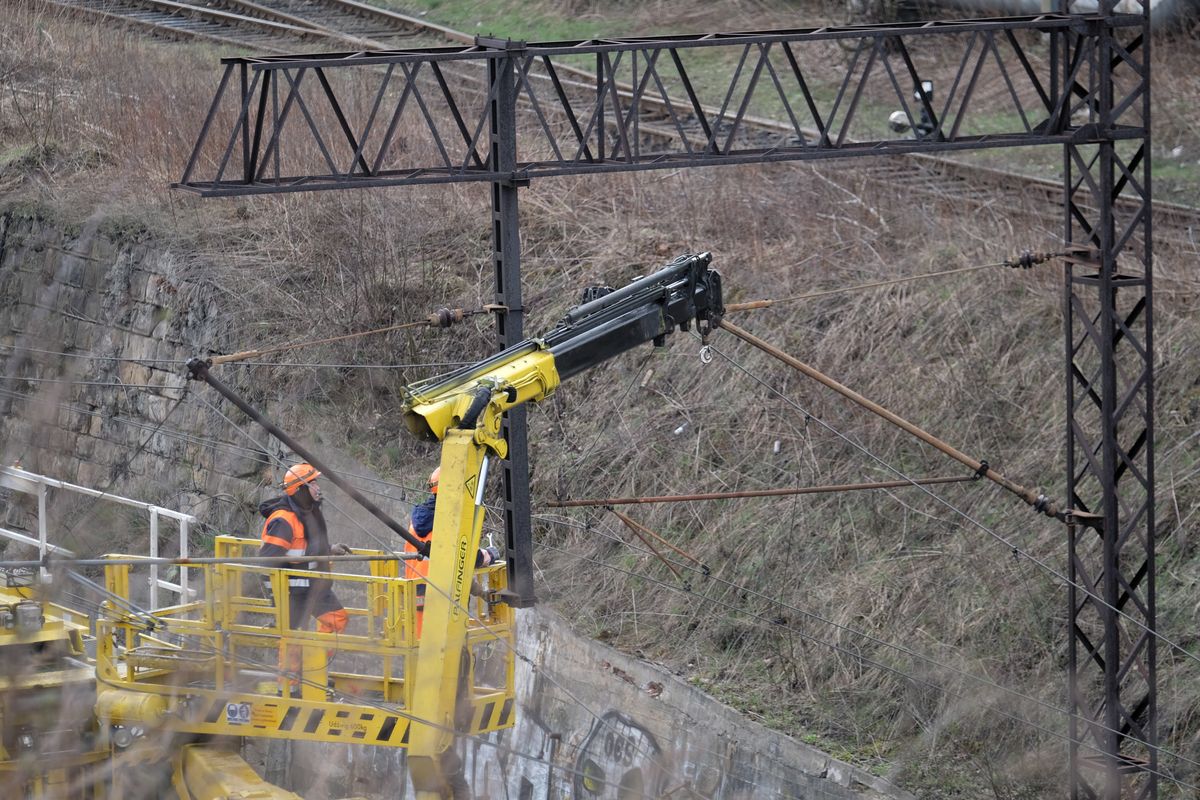 Chorzów, 06.04.2021. Prace naprawcze w rejonie ul. Poznańskiej w Chorzowie, 6 bm. Poprzedniego dnia w tym miejscu słup trakcji kolejowej przewrócił się na pociąg pasażerski. Nikomu nic się nie stało, jednak tory zostały zablokowane w obu kierunkach. Przyczyną zdarzenia mógł być silny wiatr. (aldg) PAP/Andrzej Grygiel