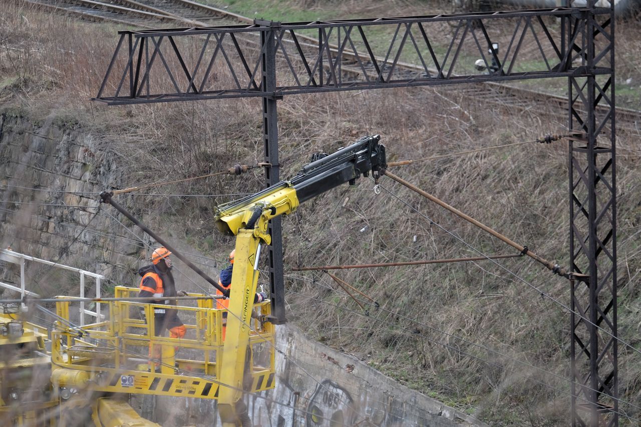 Chorzów, 06.04.2021. Prace naprawcze w rejonie ul. Poznańskiej w Chorzowie, 6 bm. Poprzedniego dnia w tym miejscu słup trakcji kolejowej przewrócił się na pociąg pasażerski. Nikomu nic się nie stało, jednak tory zostały zablokowane w obu kierunkach. Przyczyną zdarzenia mógł być silny wiatr. (aldg) PAP/Andrzej Grygiel