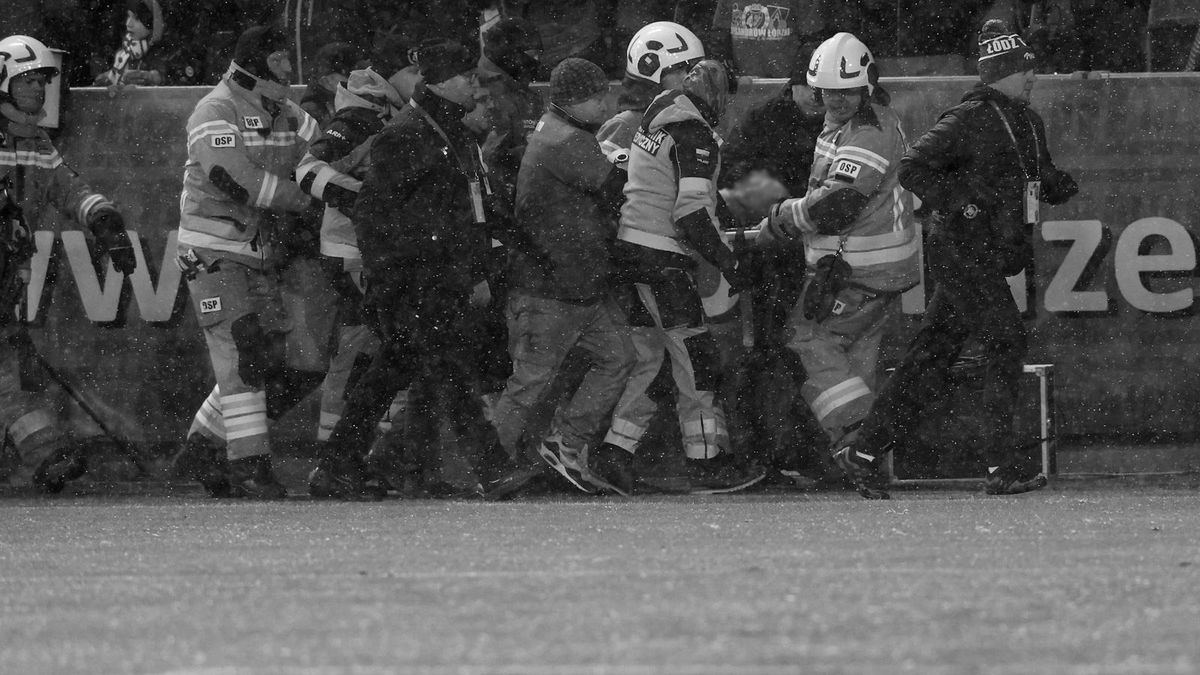 PAP/EPA / Marian Zubrzycki / Strażacy i służby ratunkowe przewożą kibica do karetki podczas meczu piłkarskiej Ekstraklasy w Łodzi