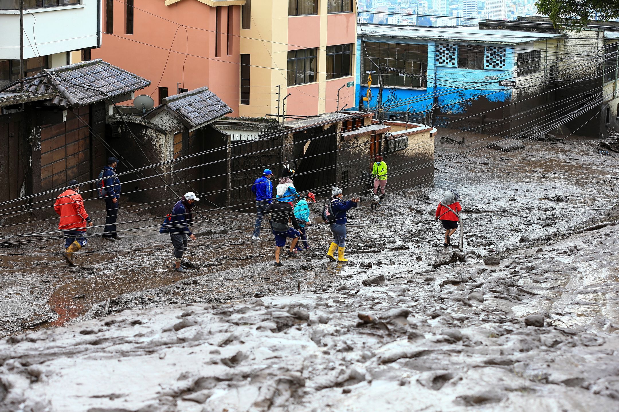 epa09721277 People walk on the mud caused by the rains that occurred on 31 January, which affected some neighborhoods in the west of the Ecuadorian capital and caused at least 18 fatalities, as reported by the authorities in Quito, Ecuador, 01 February 2022. The number of people who died on 31 January rose to 18 after a flood that affected several neighborhoods in the west of the Ecuadorian capital, a city that was hit by a heavy downpour, with record rainfall, according to authorities.  EPA/Jose Jacome 
Dostawca: PAP/EPA.