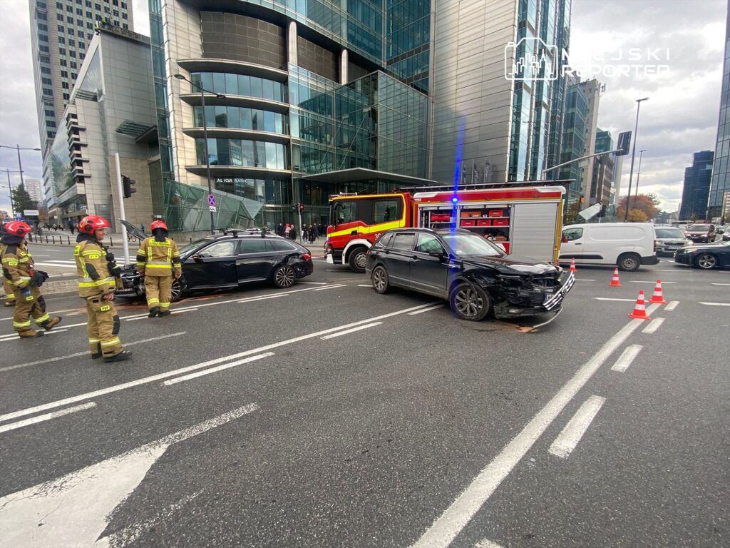 Strażacy zabezpieczają miejsce wypadku drogowego z udziałem dwóch samochodów osobowych w miejskim otoczeniu.
