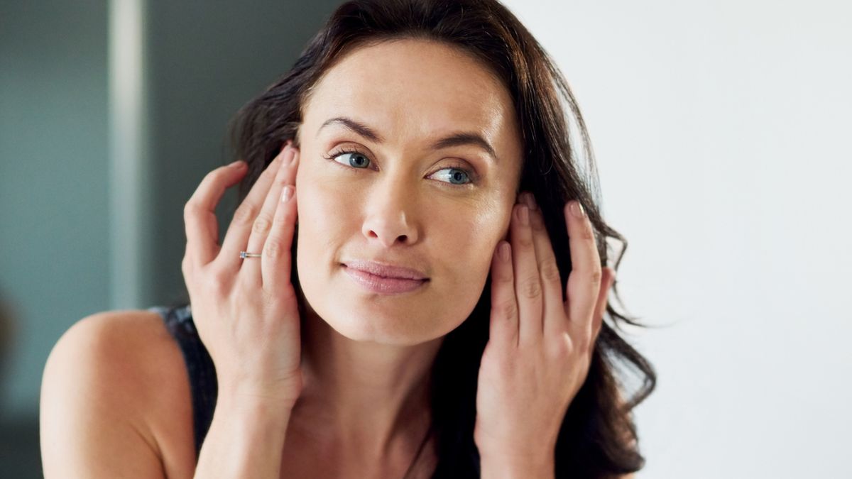 Kobieta ogląda twarz w lustrze