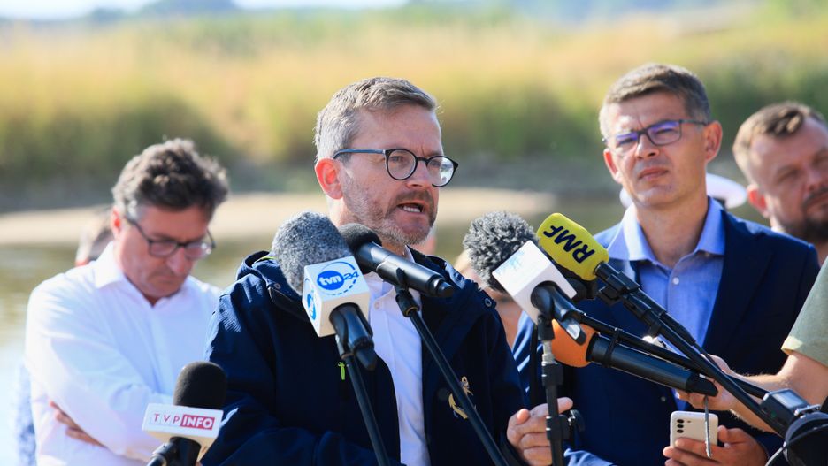 Cigacice (woj. lubuskie), 11.08.2022. Podsekretarz stanu w Ministerstwie Infrastruktury Grzegorz Witkowski (C) i prezes Państwowego Gospodarstwa Wodnego Wody Polskie Przemysław Daca (L) na konferencji prasowej we wsi Cigacice, 11 bm. Spotkanie dotyczyło zanieczyszczenia Odry. (aldg) PAP/Lech Muszyński