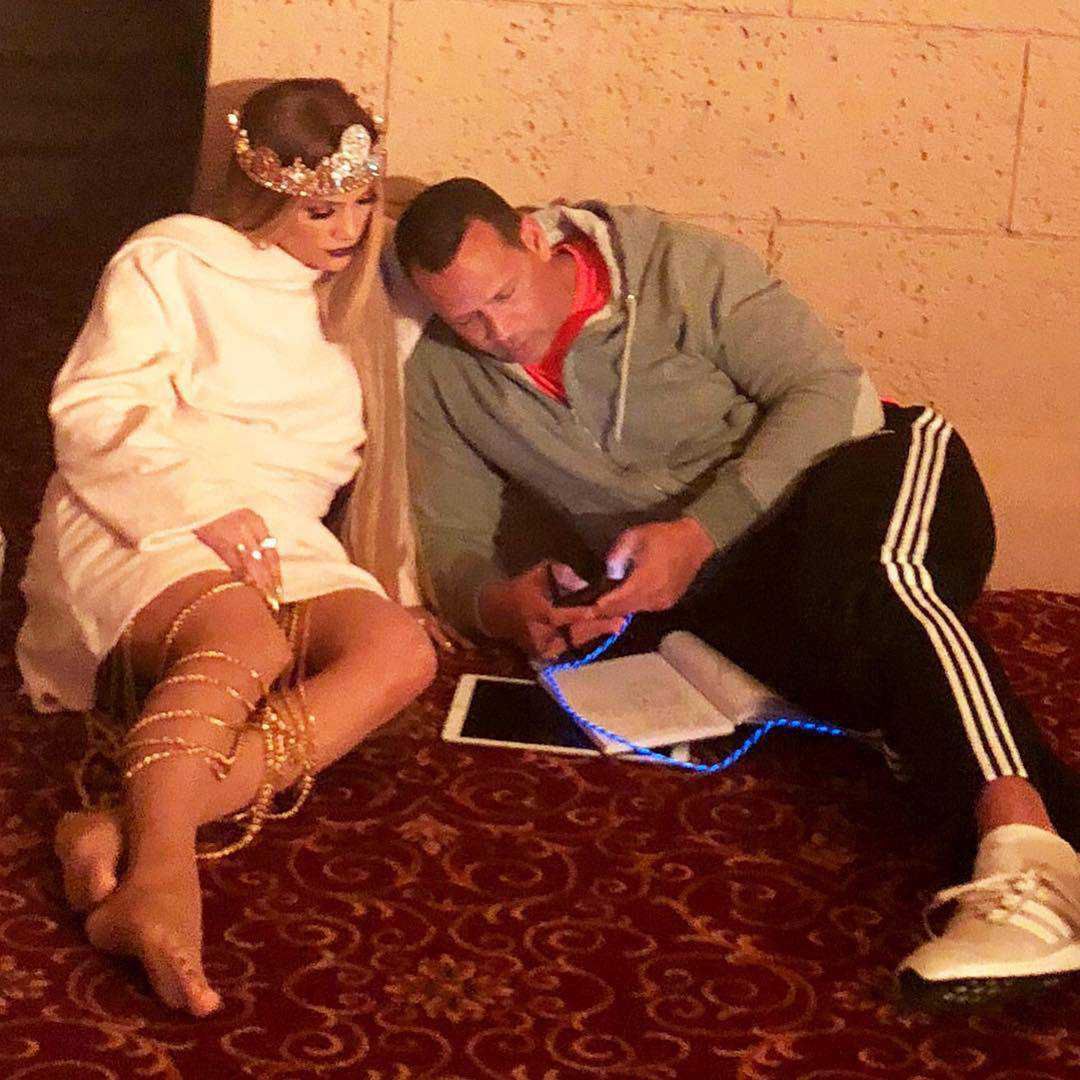 Jennifer Lopez w dziwnym stroju lezy na podłodze z ukochanym