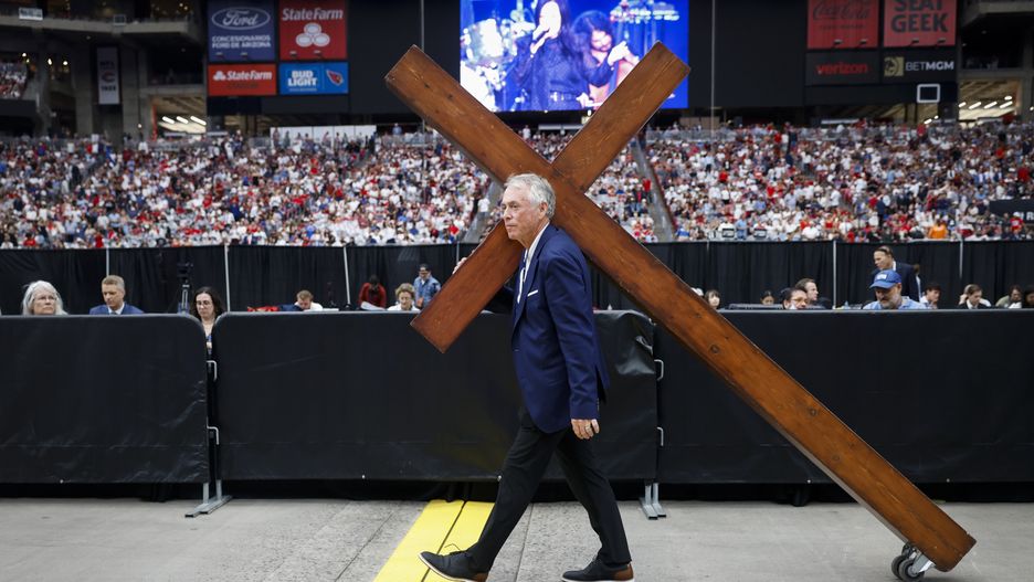 Dan Beasley carries a wooden cross through State Farm Stadium ahead of the public memorial service of political activist Charlie Kirk in Glendale, Arizona, USA, 21 September 2025. Kirk was shot and killed on 10 September during a stop on his American Comeback Tour organized by Turning Point USA at Utah Valley University. EPA/CAROLINE BREHMAN Dostawca: PAP/EPA.