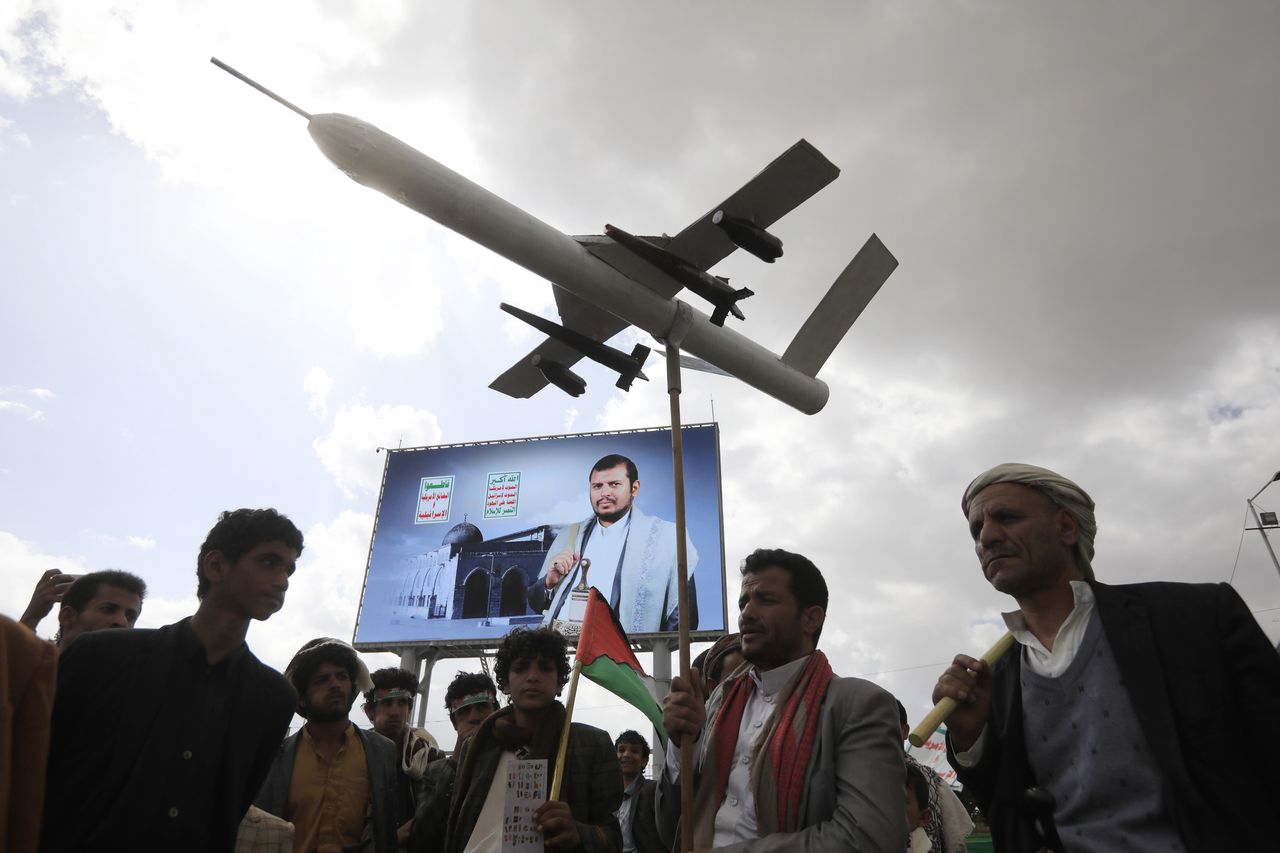 Houthi fighters (the founder of this organization is on the billboard) at a protest against the war display drones they use to attack ships in the Red Sea.