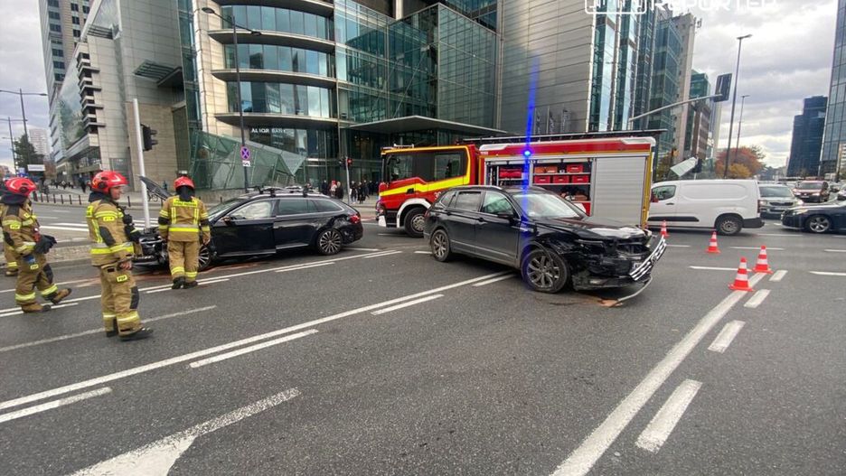 Strażacy zabezpieczają miejsce wypadku drogowego z udziałem dwóch samochodów osobowych w miejskim otoczeniu.
