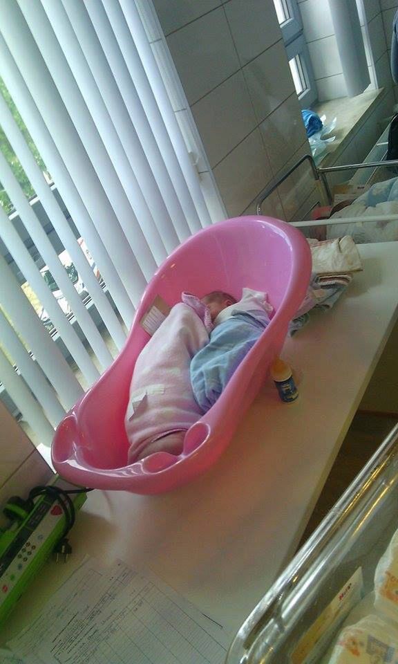 Noworodek na sali obserwacyjnej śpiący w wanience