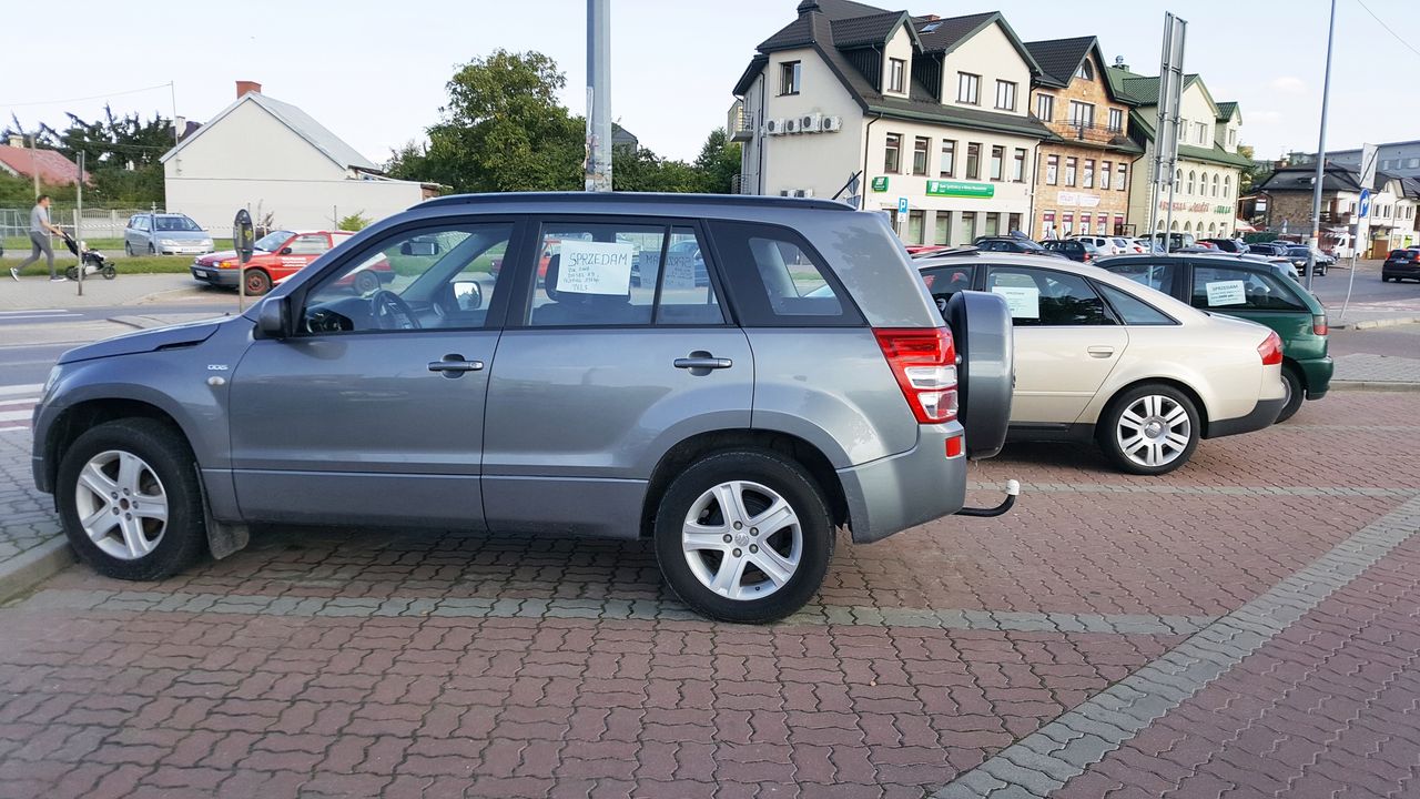 Publiczny parking z samochodami na sprzedaż. Po południu stoją praktycznie same. Przed południem zajmują miejsca osobom, które przyjeżdżają na pobliski rynek