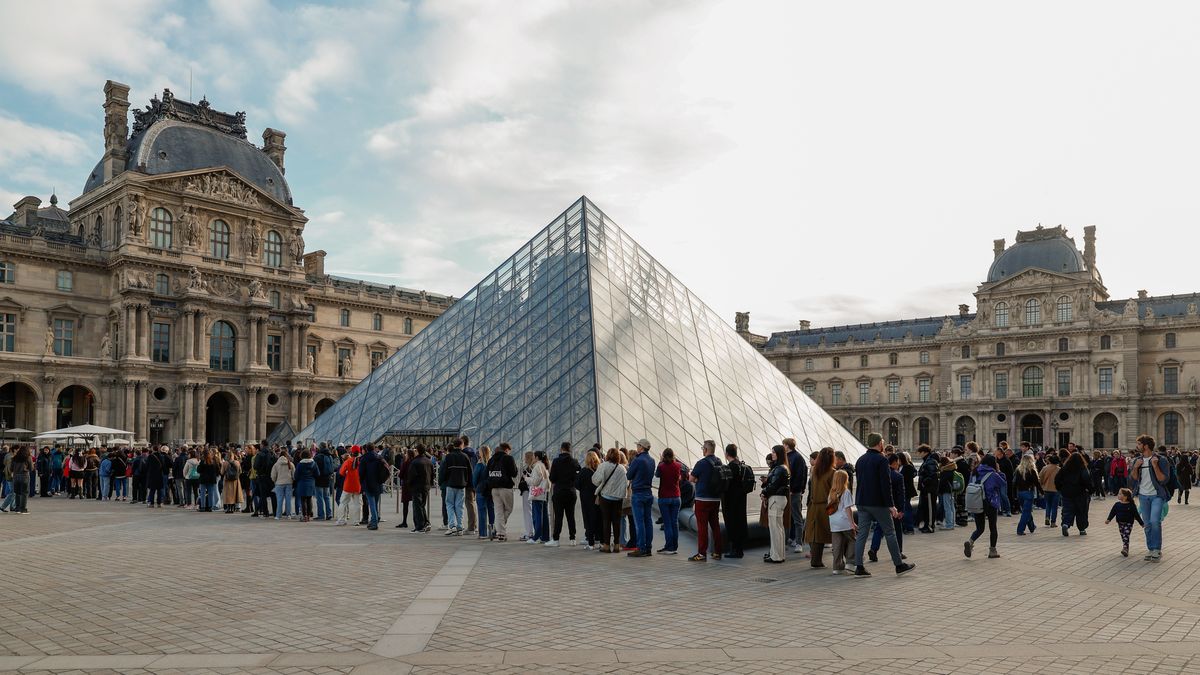 PARIS, FRANCE - OCTOBER 22: Tourists queue to enter the Louvre on October 22, 2025 in Paris, France. The Louvre reopens after a burglary of millions of pound with nine pieces of historic jewelry from the Apollo Gallery. Only Empress Eugenie's crown was found damaged outside the museum. (Photo by Pierre Suu/Getty Images)