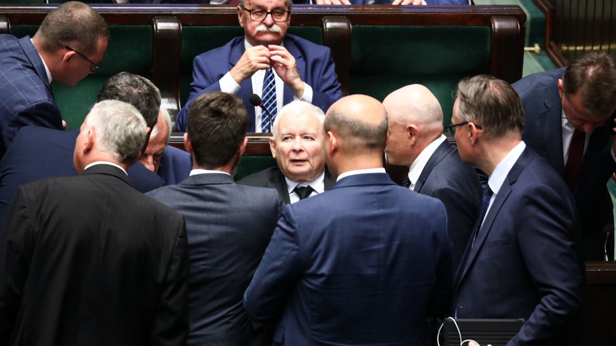 Na zdjęciu stojący posłowie PiS pochyleni nad siedzącym w ławie sejmowej Jarosławem Kaczyńskim